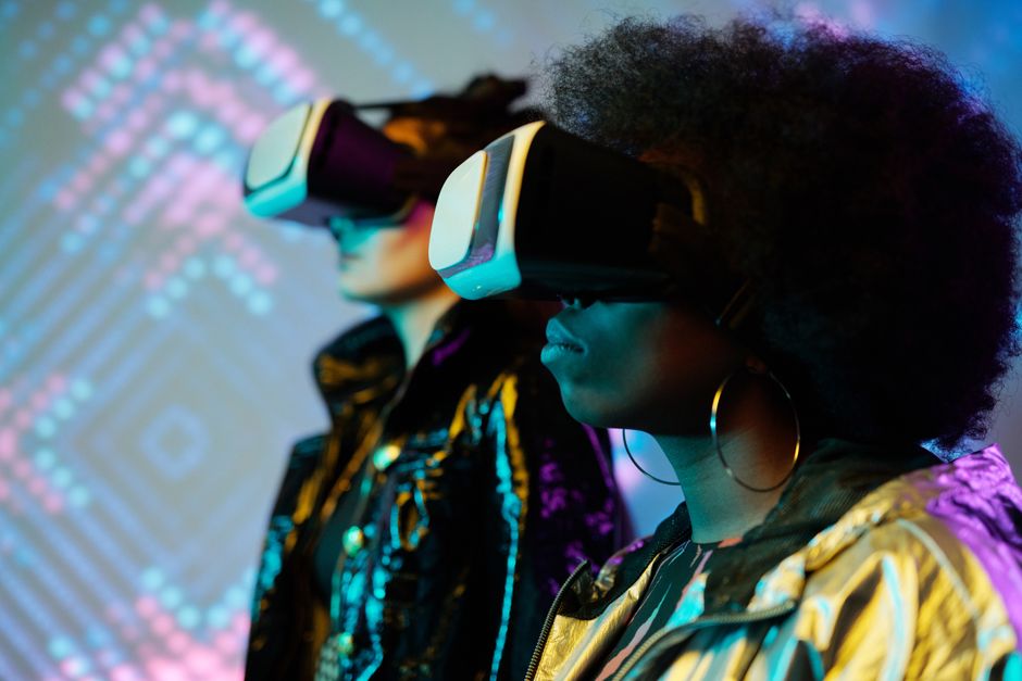 Two women wearing VR headsets immersed in a vivid digital world.